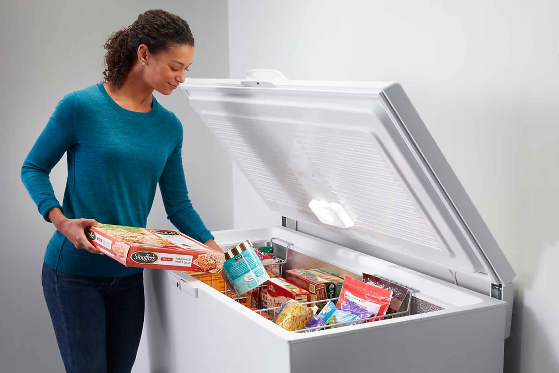 homeguide a woman placing food in a deep freezer